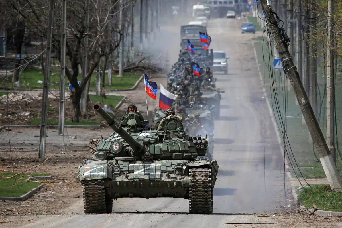 Мужчина сидит на скамейке во дворе дома, рядом — ребёнок и собака. Простая мирная сцена, в которой возвращающийся учится снова быть.